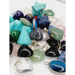 Assorted small stone pendants, each with polished gemstones in various colors and shapes, displayed on a white background.