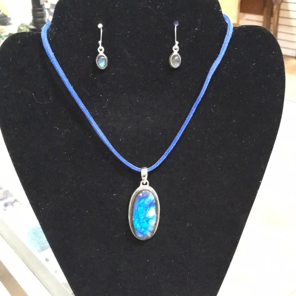 Sterling silver earrings and necklace pendant featuring labradorite stones with flashes of blue and green, displayed on a white background. Perfect for magic, protection, and mystical transformation.