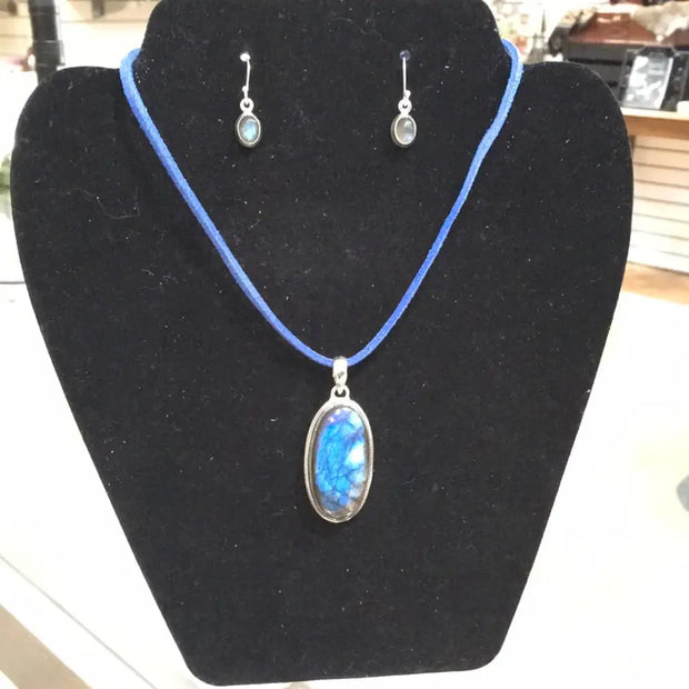 Sterling silver earrings and necklace pendant featuring labradorite stones with flashes of blue and green, displayed on a white background. Perfect for magic, protection, and mystical transformation.