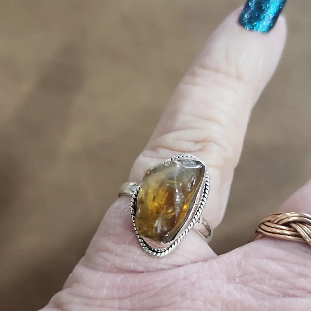 Assorted sterling silver rings featuring unique genuine gemstones in various shapes and colors, displayed on a white background. Perfect for crystal energy, personal style, and one-of-a-kind magic.