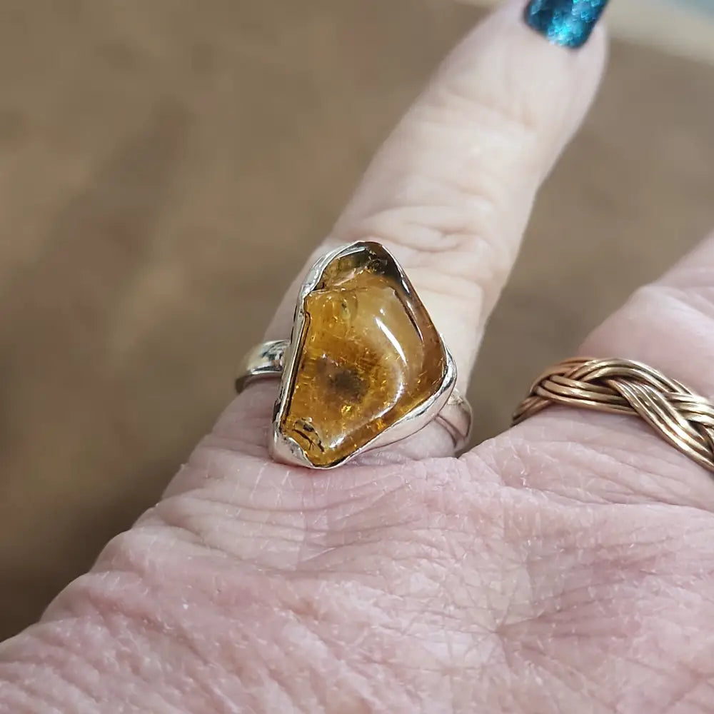 Assorted sterling silver rings featuring unique genuine gemstones in various shapes and colors, displayed on a white background. Perfect for crystal energy, personal style, and one-of-a-kind magic.