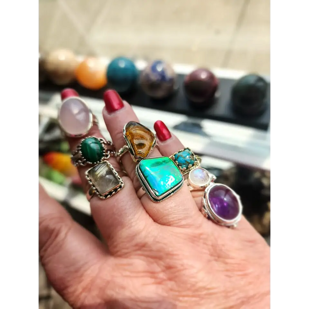 Assorted sterling silver rings featuring unique genuine gemstones in various shapes and colors, displayed on a white background. Perfect for crystal energy, personal style, and one-of-a-kind magic.

